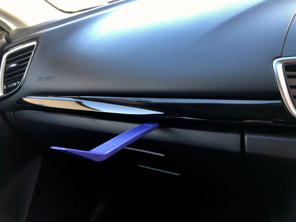 First step in the Mazda ghost touch workaround it to remove the trim with a plastic trim removal tool